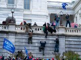 Simpatizantes de Trump trepan el muro exterior del Capitolio, en Washington D. C., el miércoles pasado.