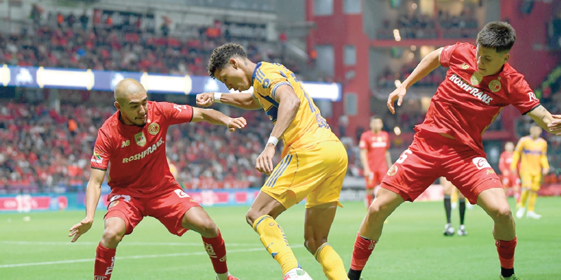 OZZIEL HERRERA pelea con dos jugadores de Toluca un balón, el pasado julio, en duelo de temporada regulara.
