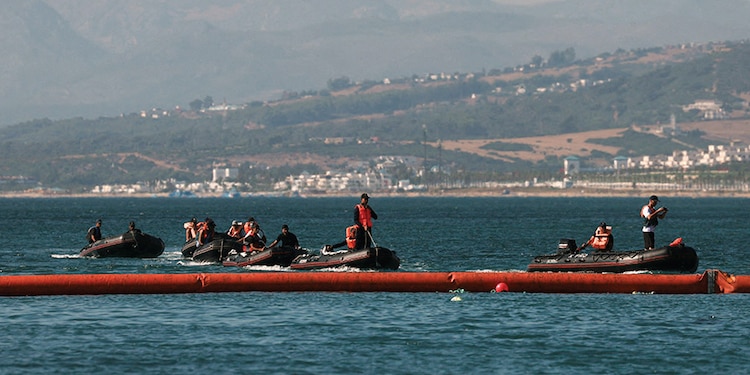 Instalación de la barrera flotante en el enclave español, ayer, tras la irrupción masiva de marroquíes.