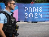 Un oficial de policía camina junto a un letrero de los Juegos Olímpicos de París 2024