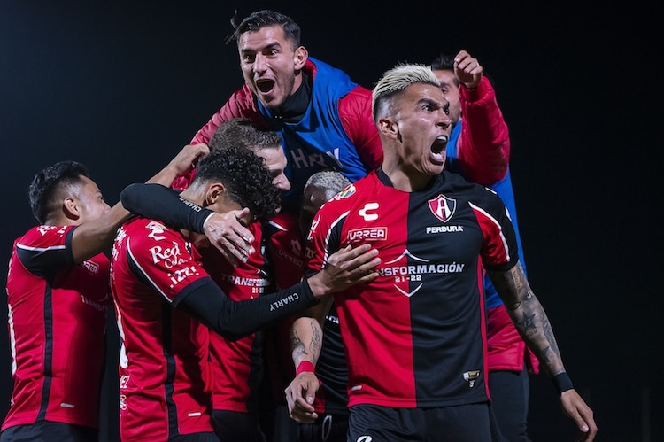 Jugadores rojinegros celebran su única anotación, ayer.
