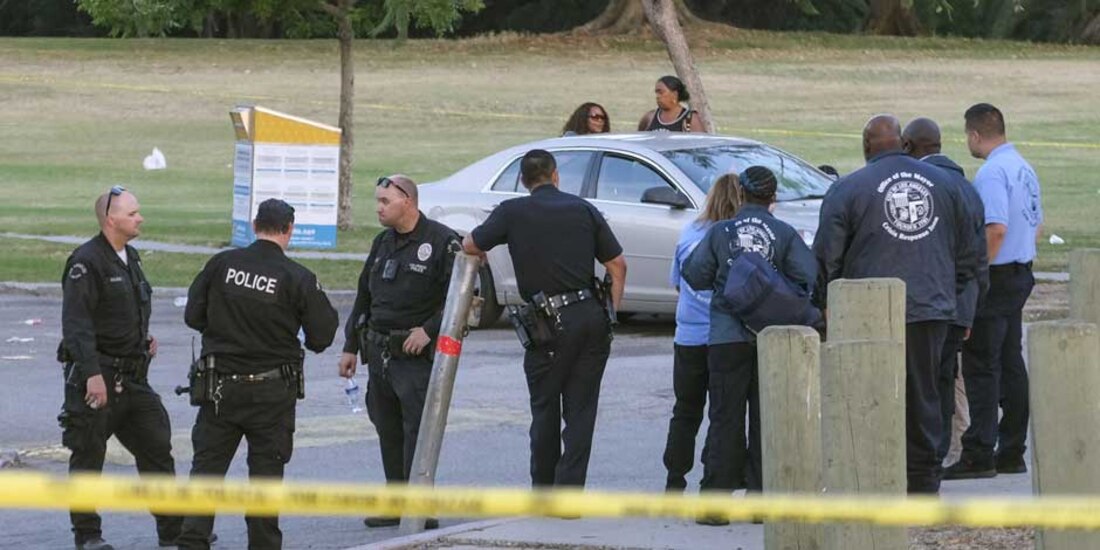 Los oficiales de policía se paran cerca de la escena de un tiroteo en Peck Park en San Pedro, California,