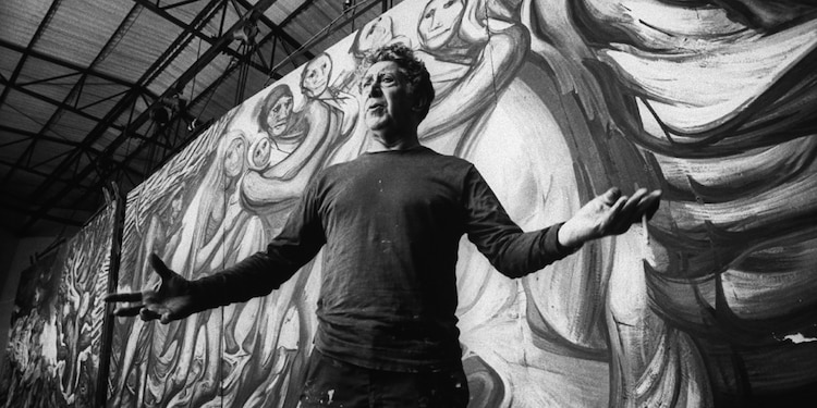 Siqueiros frente a uno de sus murales en preparación.