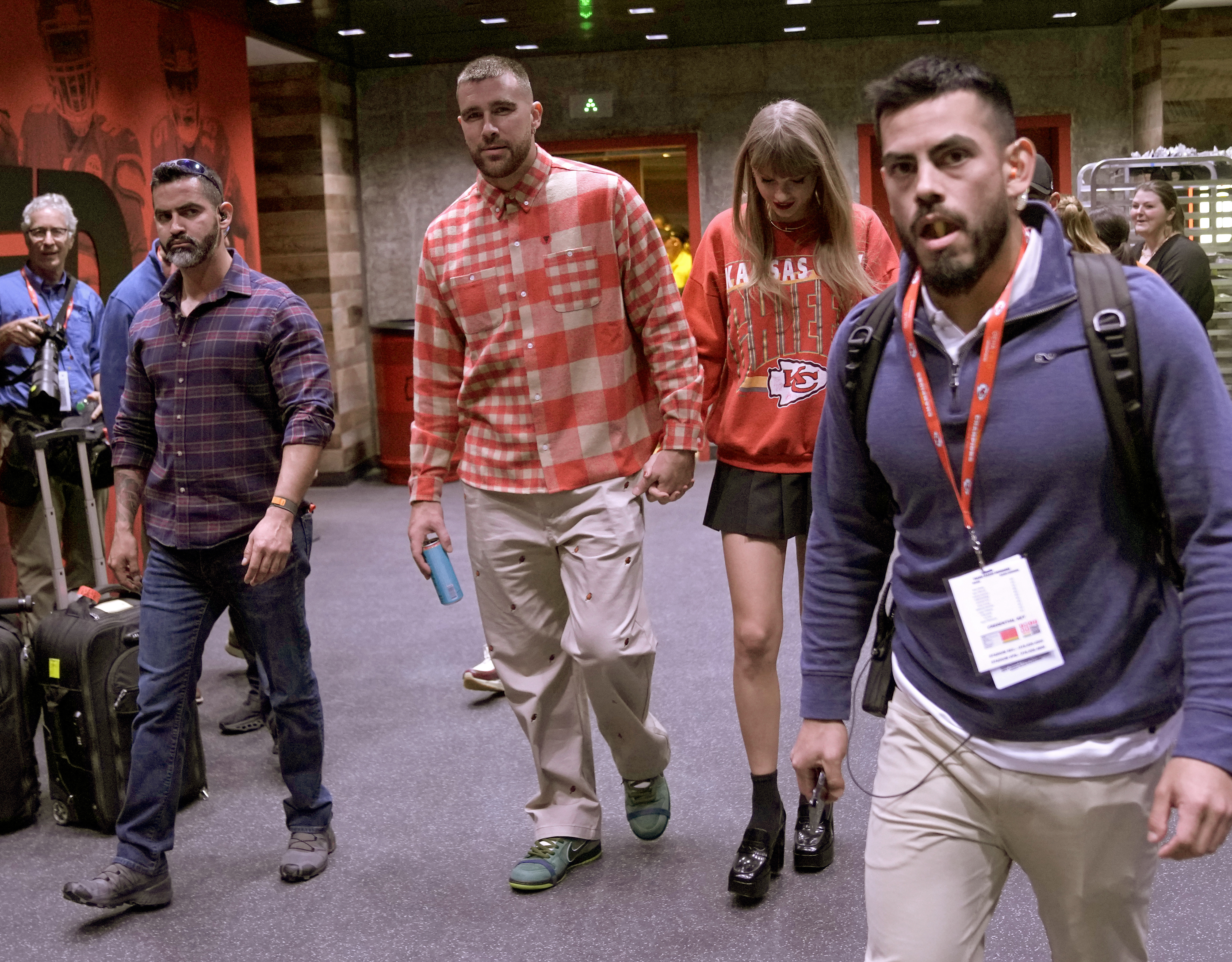 El tight end de los Chiefs de Kansas City, Travis Kelce, centro a la izquierda, y la cantante Taylor Swift salen del estadio Arrowhead después de un partido de la NFL entre los Chiefs y los Chargers