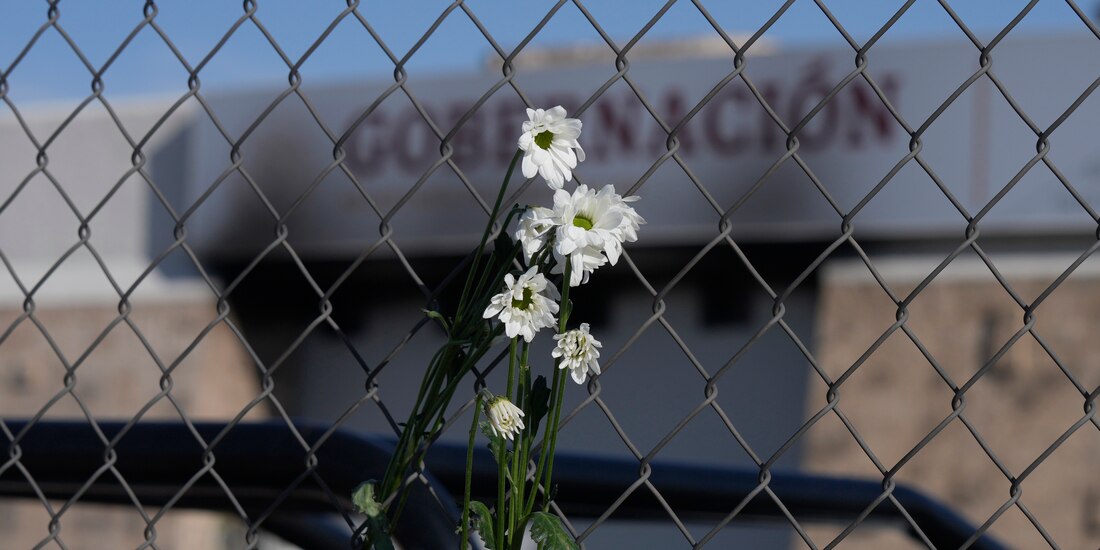 Flores marchitas cuelgan de la cerca frente a un centro de detención de inmigrantes donde decenas de personas murieron en un incendio en Ciudad Juárez, México,
