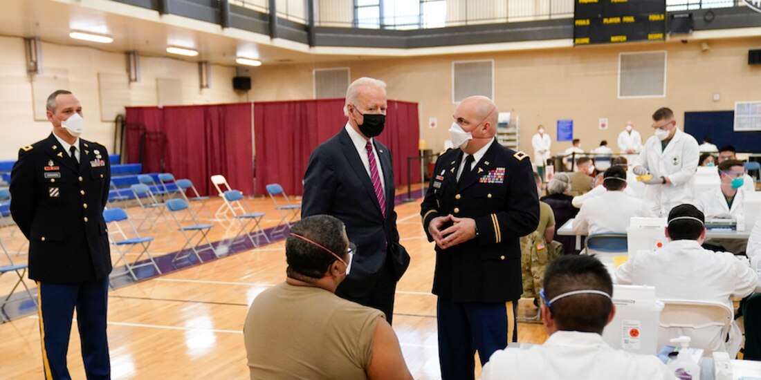 El presidente de EU, Joe Biden (izq., de pie), recorrió ayer un centro de vacunación miltar en Bethesa, Maryland.