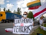 Una manifestante lleva un cartel que dice "Lukashenko = Terrorista" en una protesta contra el presidente bielorruso.