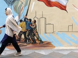 UNA MUJER iraní camina junto a un
mural en una calle de Teherán, ayer