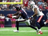 El receptor abierto de los Texans, Brandin Cooks (13), atrapa un pase mientras el esquinero de los Patriots, J.C. Jackson (27), defiende.
