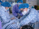 Trabajadores médicos auxilian a un paciente en un hospital en Meishan