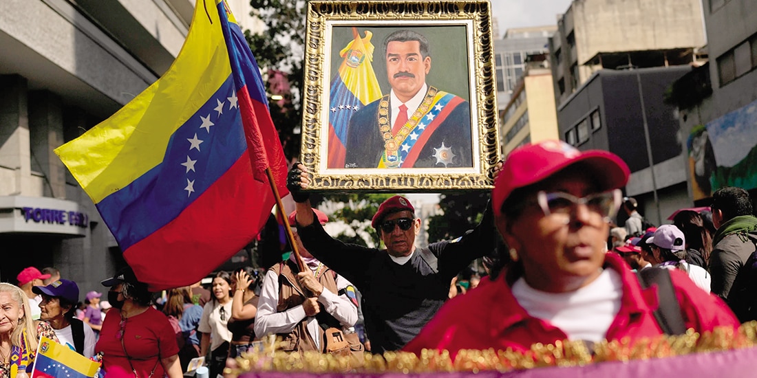 Un simpatizante del gobierno sostiene una imagen del presidente Nicolás Maduro durante una marcha de mujeres para exigir su regreso, el 6 de enero.