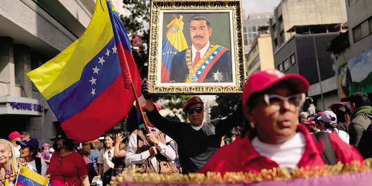 Un simpatizante del gobierno sostiene una imagen del presidente Nicolás Maduro durante una marcha de mujeres para exigir su regreso, el 6 de enero.