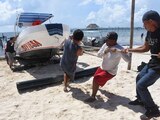 Pescadores retiran sus embarcaciones del mar, horas antes de la llegada de Grace, que este jueves impactó a la Península de Yucatán.