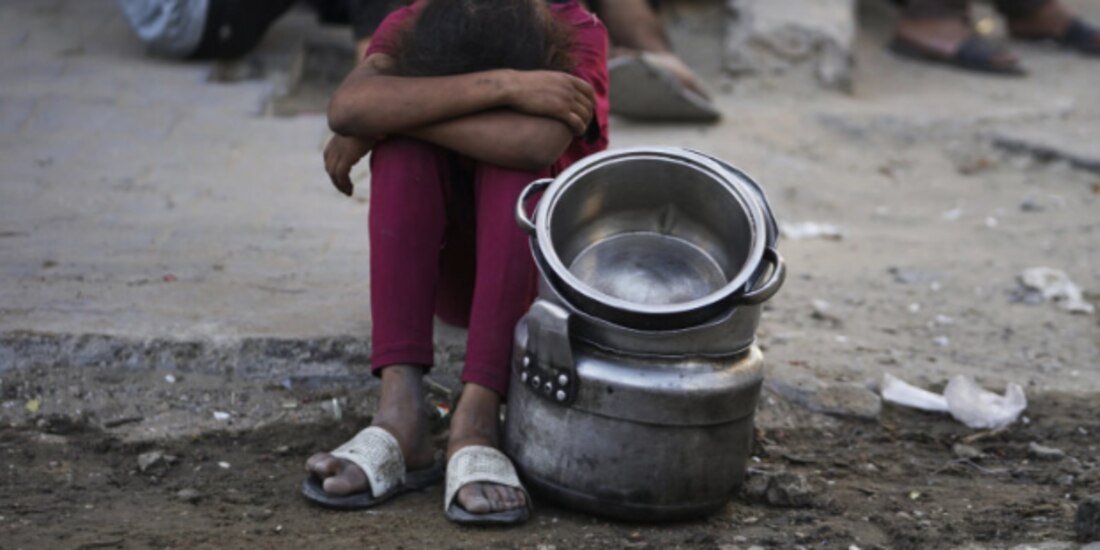 Los palestinos esperan comida donada en una cocina comunitaria en la ciudad de Gaza, el pasado 14 de julio.