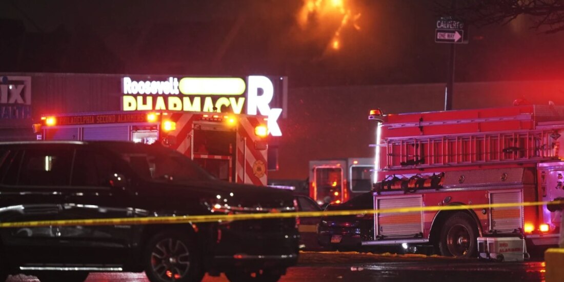 La imagen muestra el lugar del accidente de una avioneta en el noreste de Filadelfia, ocurrida poco después de su despegue. Se pueden ver viviendas afectadas por el fuego generado por el impacto, mientras los equipos de emergencia trabajan en la zona.