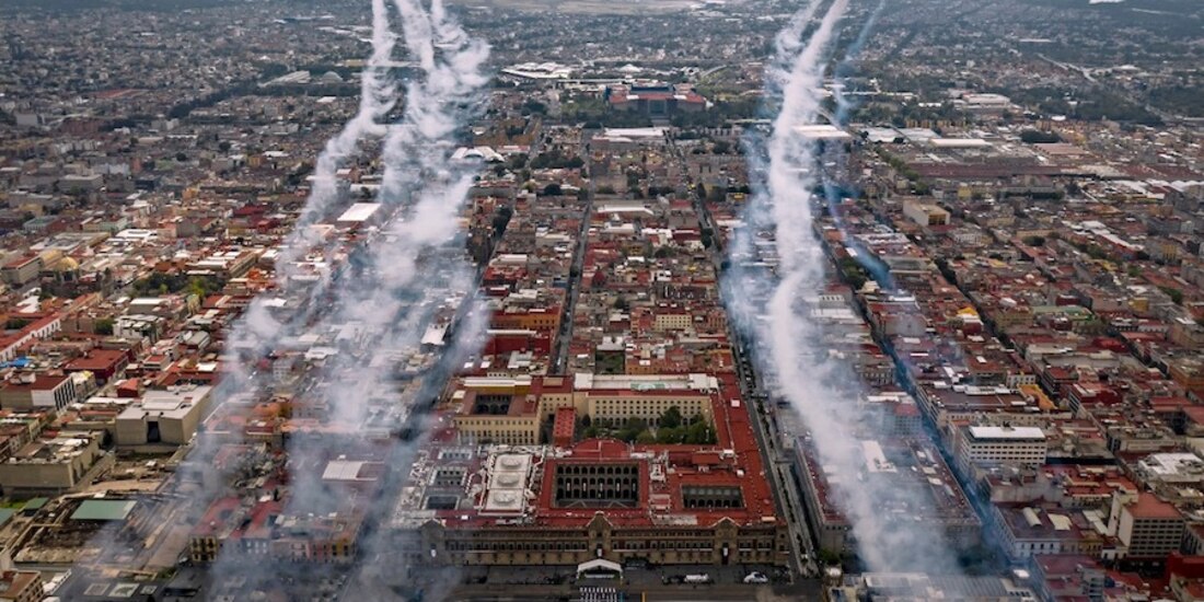 Aviones de la Fuerza Aérea sobrevuelan las calles de la capital, lanzando humo de colores, ayer.