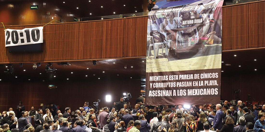 Los diputados del PRI mostraron una manta donde aparece la presidenta de Morena, Luisa María Alcalde, y el diputado Arturo Ávila, vacacionando en meses pasados, el miércoles.