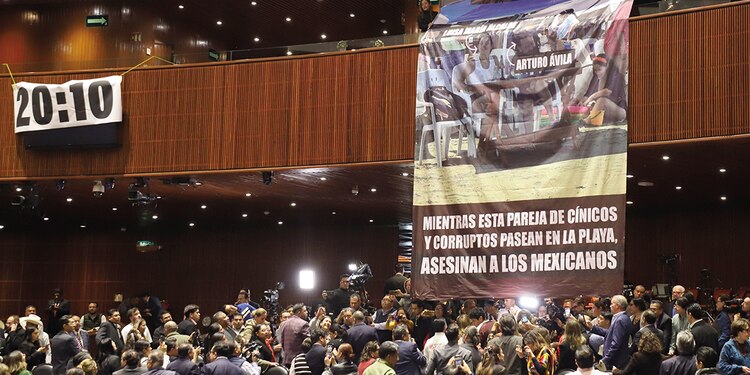 Los diputados del PRI mostraron una manta donde aparece la presidenta de Morena, Luisa María Alcalde, y el diputado Arturo Ávila, vacacionando en meses pasados, el miércoles.