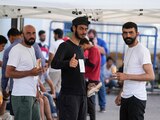 Migrantes rescatados saludan a las cámaras desde el refugio en Kalamata, ayer.