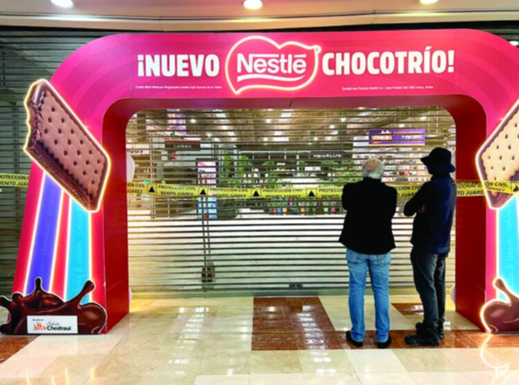 Dos hombres miran los daños por la caída de un plafón, ayer.