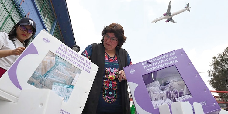 Una mujer mete a las urnas del IECM sus votos en las consultas, en una fotografía ilustrativa.