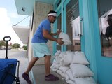 Un residente coloca sacos de arena frente a una entrada de cristal en Texas, ayer.