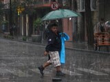 Un capitalino se camina bajo la lluvia mientras se cubre con un paraguas en calles de la CDMX.