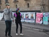 Jóvenes miran retratos de personas no localizadas, en una protesta del 1 de julio.