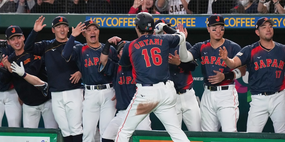 Shohei Ohtani (de espaldas) celebra con sus compañeros de Japón luego de batear un jonrón en el Clásico Mundial de Beisbol 2026