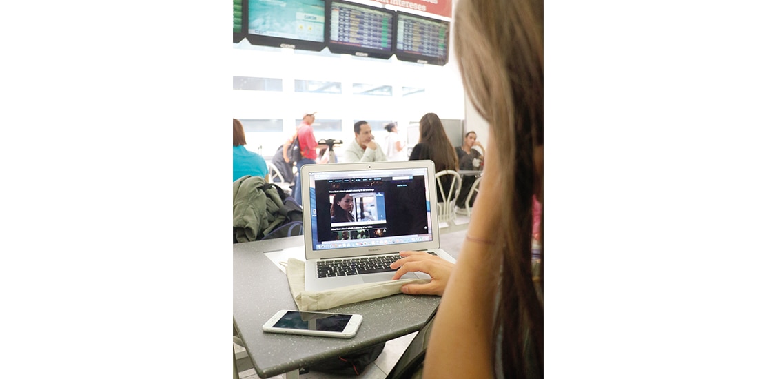 Usuaria de tecnología telefónica y digital en el Aeropuerto Internacional de la CDMX, en imagen de archivo.