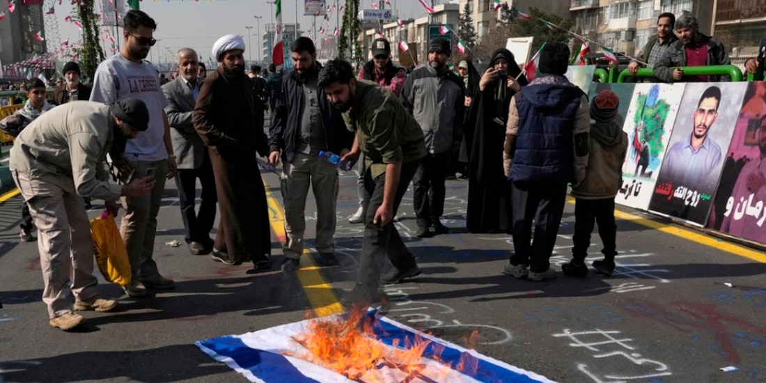 Manifestantes iraníes queman una bandera de Israel.