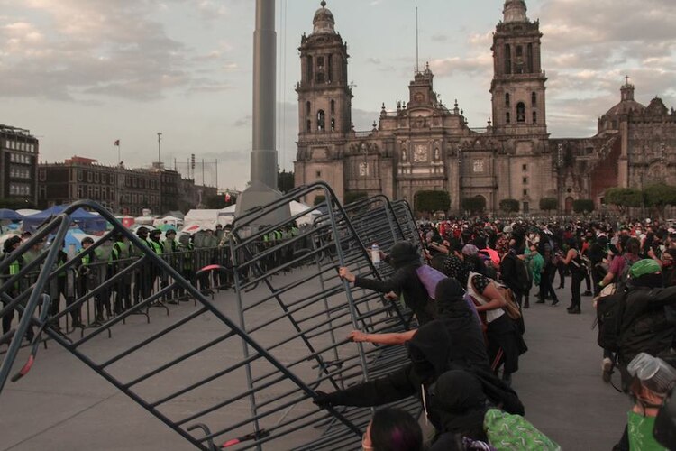 Encapuchadas derriban el cerco que resguardaba a integrantes de Frena, ayer.