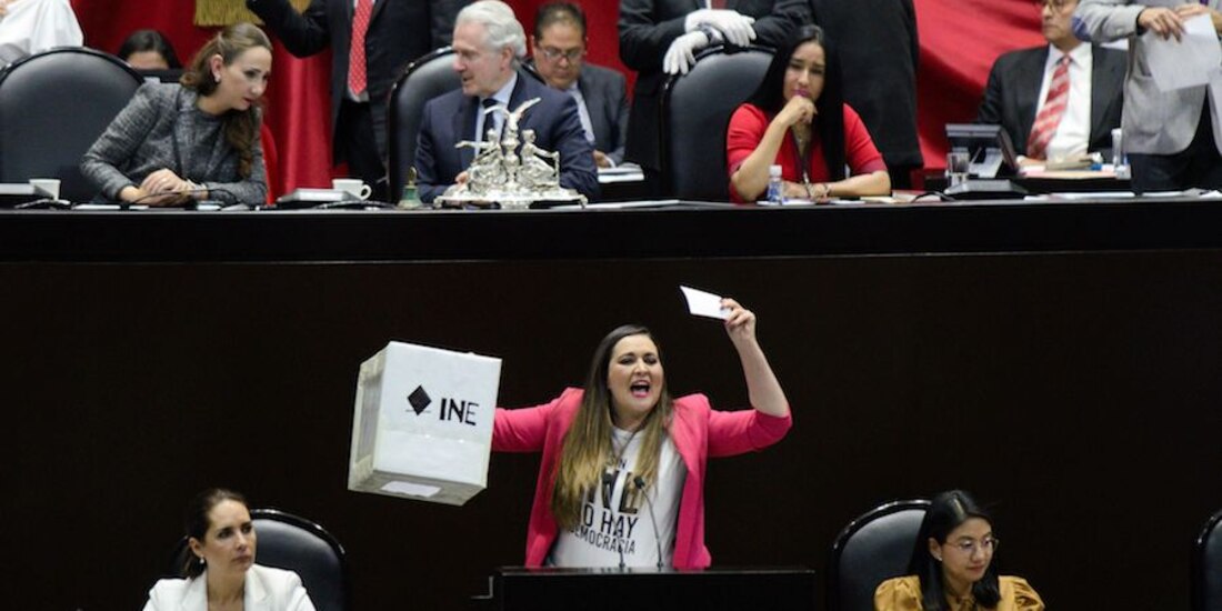 La diputada priista Cynthia López Castro muestra una urna en la tribuna, ayer, durante el debate.