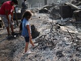 Three years old Ashley looks on her burned bicycle after wildfires destroyed a neighbourhood in Bear Creek, Phoenix, Oregon, U.S., September 10, 2020. REUTERS/Carlos Barria