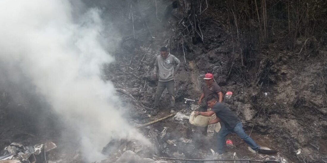 Voluntarios intentan apagar el fuego que dejó el desplome de la avioneta, ayer, en la frontera de Chiapas y Guatemala.