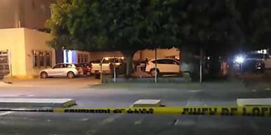 Elementos policiacos acordonan el estacionamiento de un hospital tras el ataque armado a una pareja.