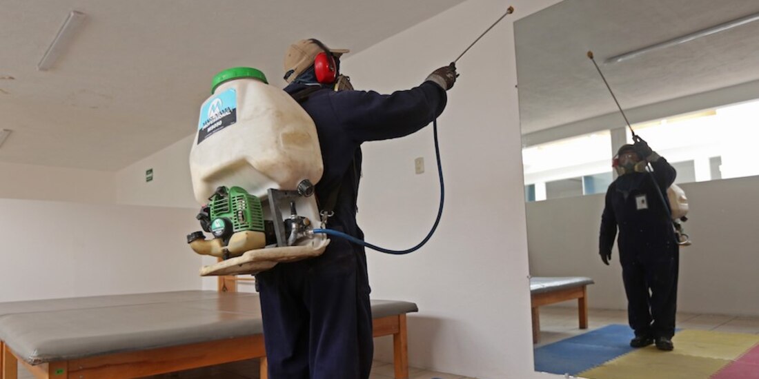 Un trabajador sanitiza espacios educativos en Zapopan, Jalisco, donde el mes pasado hubo reportes de casos agudos de dengue y Covid-19.