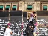 Mujeres colocaron ayer flores, cruces rosas, moños morados, veladoras y nombres de víctimas de feminicidio en las vallas colocadas alrededor de Palacio Nacional.