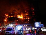 Bomberos rescatan a 2 personas en un balcón en llamas en Valencia, España.