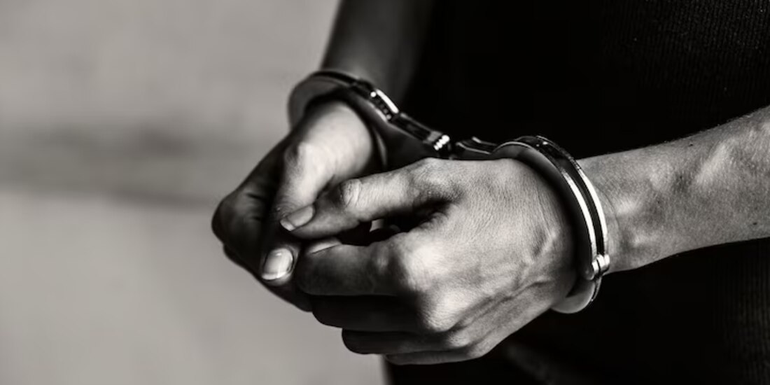 En la imagen ilustrativa, una persona detenida con esposas en las manos