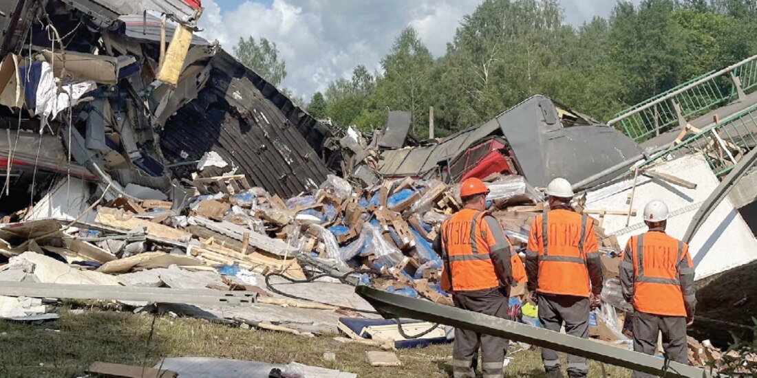 Especialistas de los servicios de emergencia trabajan en el lugar, después de que un puente de carretera se derrumbara sobre las vías del tren debido por una explosión en Bryansk, Rusia, ayer.