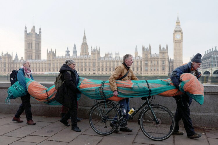 Activistas por el medio ambiente, en Londres, llevan una gran pancarta en oposición a la investidura de Donald Trump.