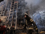 Un bombero camina junto a un edificio destruido en Kiev, ayer; Rusia estrecha cerco.