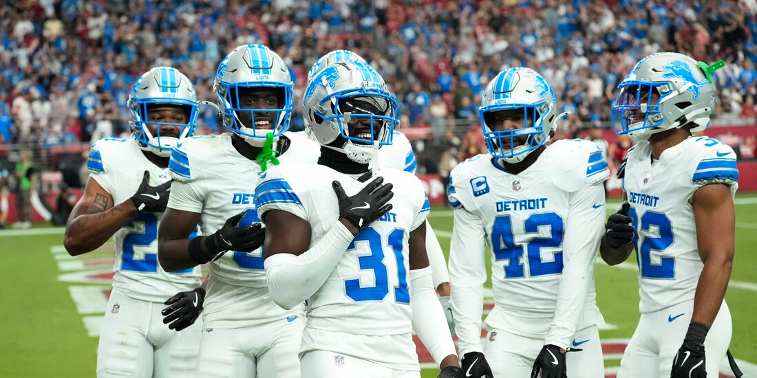 Jugadores de los Detroit Lions celebran una intercepción ante Arizona Cardinals en la NLF