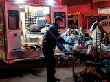 PERSONAL paramédico sube a un herido a una ambulancia tras un incendio, ayer.
