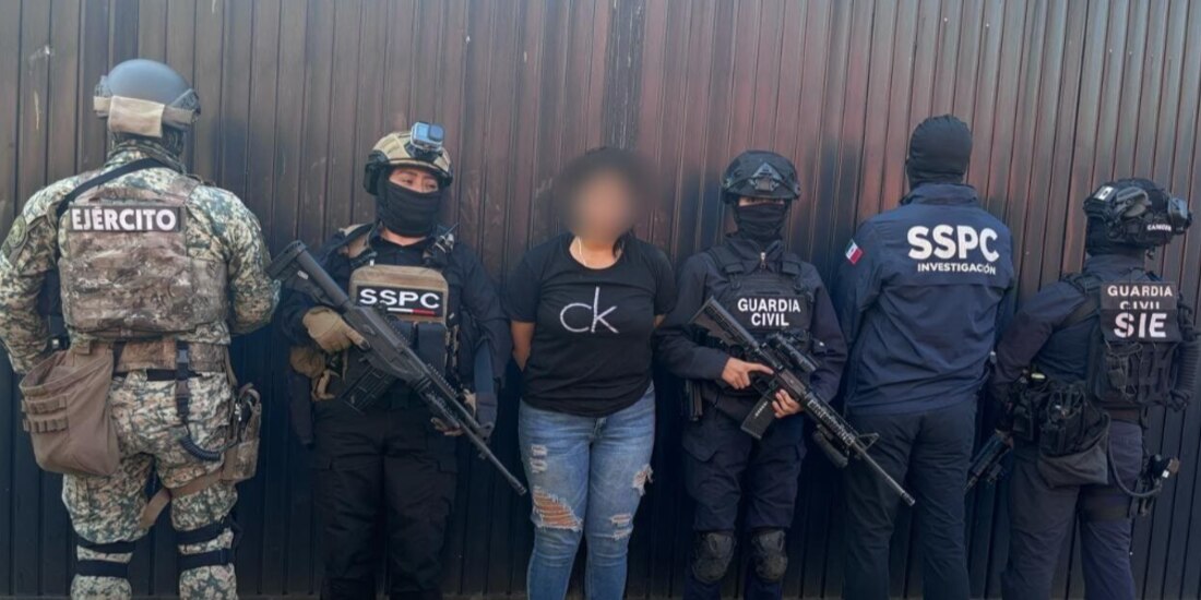 Elementos de seguridad con Leslie “N”, luego de su aprehensión, ayer.