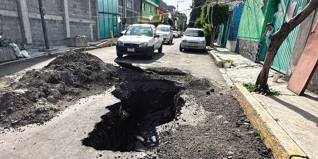 UNA VECINA mira
el socavón afuera
de su casa, ayer