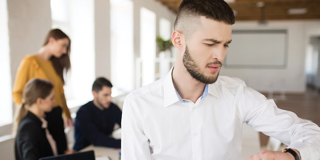 Hombre mira su reloj durante su jornada laboral.