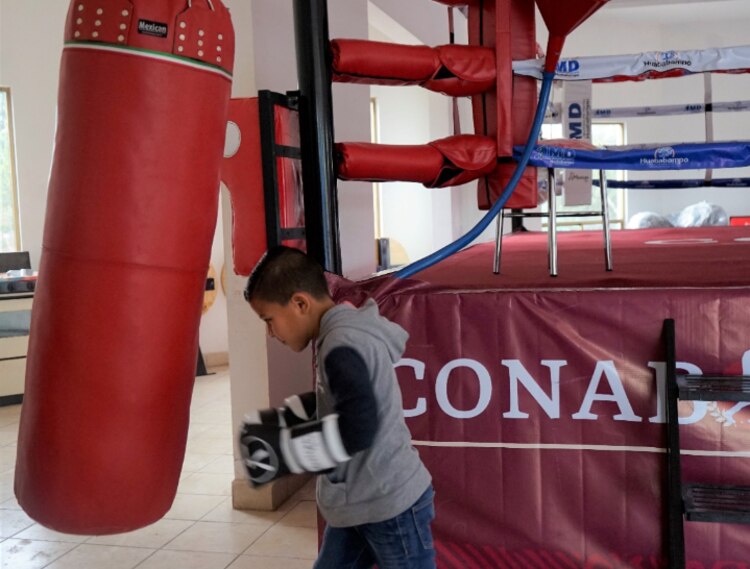 Un menor de edad se prueba con un costal de box.