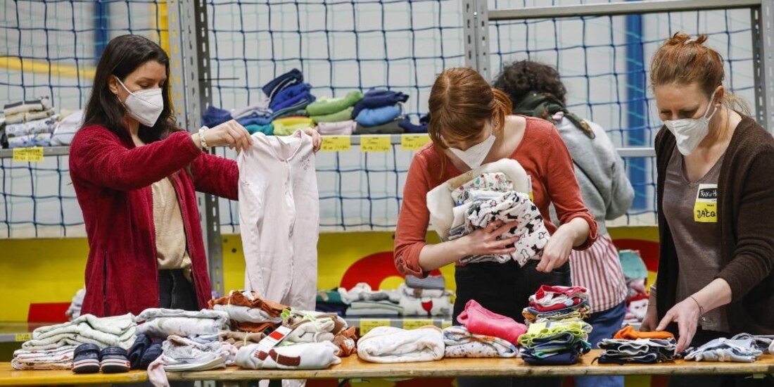 Voluntarios organizan ropa donada para personas ucranianas que viven asediadas por la guerra